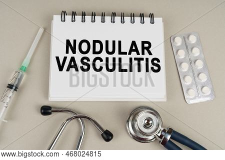 Medical Concept. On A Gray Surface, A Syringe, A Thermometer, A Stethoscope, A Blister And A Notepad