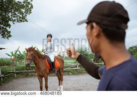 Equestrian Female Athlete Riding Horse Given Thumbs Up By Coach