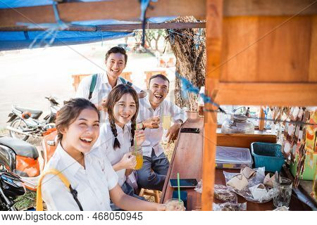 Group Of Asian Students Enjoying A Drink At An Angkringan