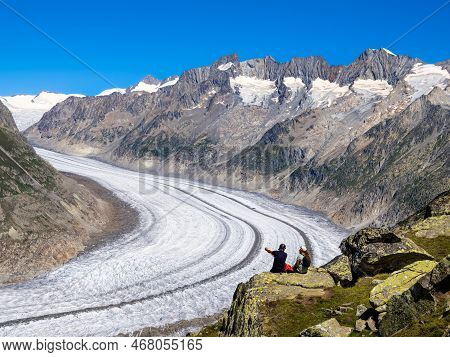 Bettmeralp, Switzerland - July 16, 2022: A Young Couple Admires The Glacial Landscape Of Aletsch Gla