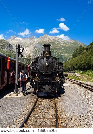 Gletsch, Switzerland - July 15, 2022: A Historic Train With A Steam Locomotive On The Furka Railway 
