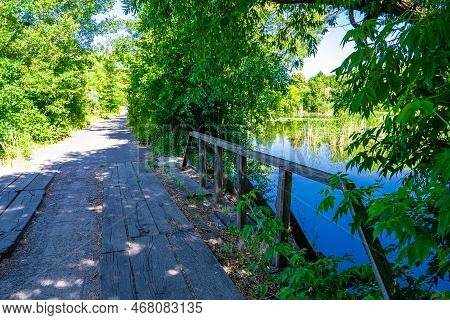 Beautifully Standing Old Wooden Bridge Over River In Colored Background Close Up