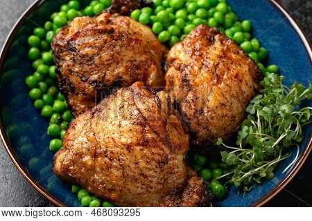 Baked Chicken Thighs With Green Peas In Blue Plate