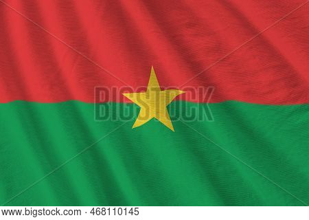 Burkina Faso Flag With Big Folds Waving Close Up Under The Studio Light Indoors. The Official Symbol