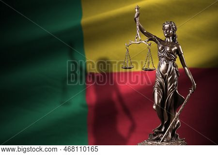 Benin Flag With Statue Of Lady Justice And Judicial Scales In Dark Room. Concept Of Judgement And Pu