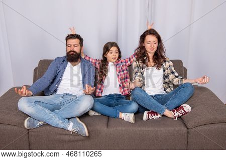 Parents With Kid Maditating Together At Home, Yoga
