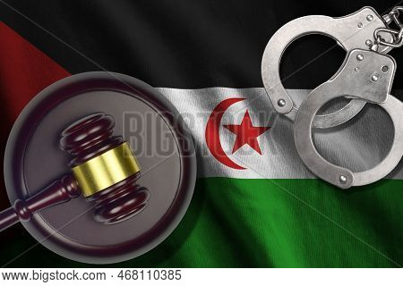 Western Sahara Flag With Judge Mallet And Handcuffs In Dark Room. Concept Of Criminal And Punishment