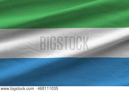 Sierra Leone Flag With Big Folds Waving Close Up Under The Studio Light Indoors. The Official Symbol
