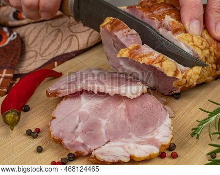 A Piece Of Juicy And Tasty Bacon Is Cut With A Kitchen Knife Into Appetizing Pieces. Close-up Of Fem