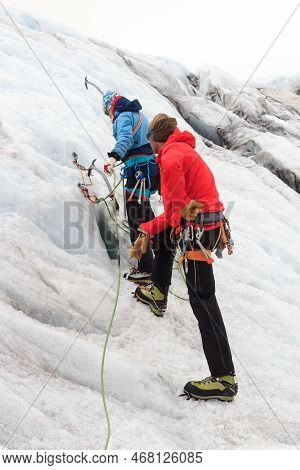 Woman Training To Build An Ice Anchor With Ice Screws Under Supervision Of A Mountain Guide At Glaci