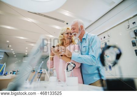 Seniors Shopping Appliences And Gadgets In Tech Store.