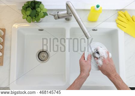 Man Washing Plate In Kitchen Sink, Top View