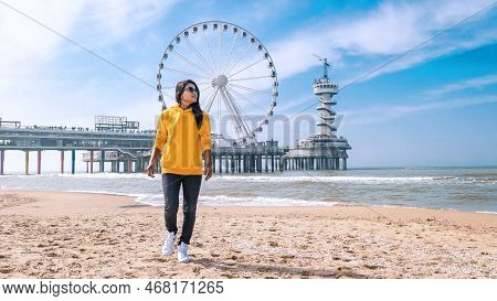 Woman On The Beach Of Scheveningen Netherlands During Spring, Ferris Wheel The Pier At Scheveningen