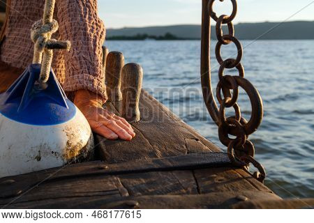 Close Up Of Wrinkled Sailor Hand, Sailing Into The Sunset. Experienced Marine Sailing At Sea