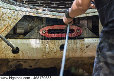 Man Use Winch Device At Front Of Pick Up Off Road Vehicle. Man Use The Winch Helps To Drag The Car W