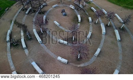 Massive Concrete Blocks Of Bench In The Park Are Connected By Granite Blocks In The Shape Of A Spira