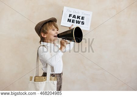 Newsboy Shouting Against Grunge Wall Background. Boy Selling Fake News