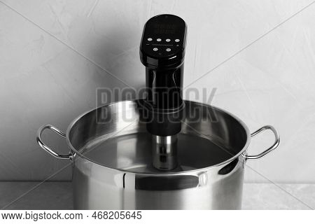 Sous Vide Cooker In Pot On Light Grey Table. Thermal Immersion Circulator
