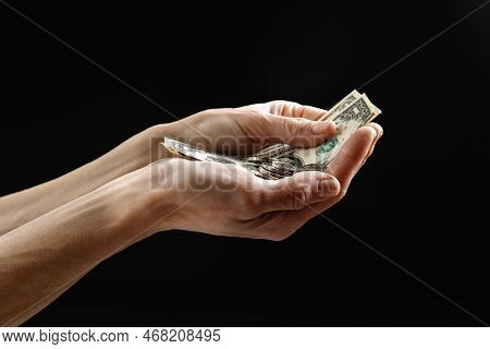 Aid Money In Usa. A Poor Man Holding Not Much Money, Dollars. The Concept Of Helping Homeless And Un