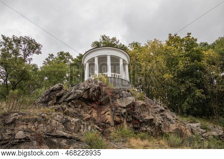 White Gazebo In City Park Of Zhytomyr, Ukraine At Sunny Autumn Day. Picturesque View On Colourful Hi