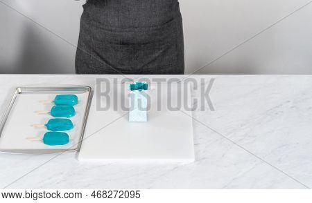 Dipping Frozen Cakesicles Into Melted Chocolate To Prepare Mermaid Cakesicles.