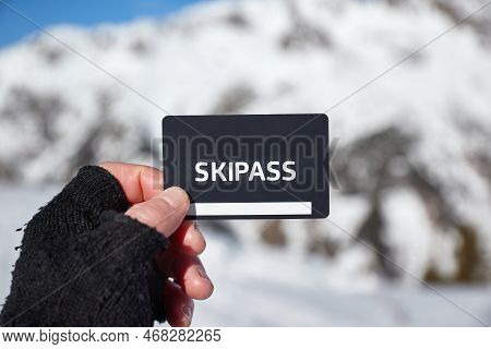 Ski Pass Held In Hand By Skier In A Snowy Mountain Landscape