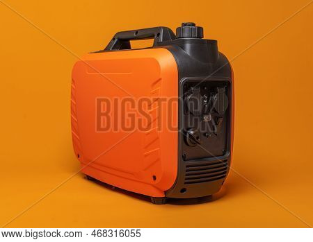 Electricity Generator. Inverter Gasoline Generator On An Orange Background. Studio Shot.