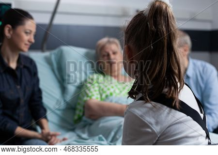 Unrecognizable Little Girl Chatting With Lady Bedridden Suffering Degenerative Disease. Toddler Acco