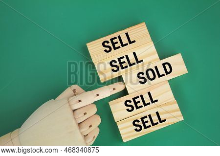 Hand Pushing Stick With Word Sold In Sell Line. The Concept Of Sell And Sold. The Concept Of A House