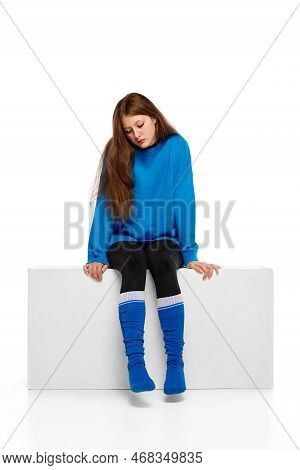 Portrait Of Teen Sad Girl Sitting Over White Background. Suffering From Apation, Stress And Depressi