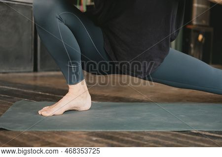 Close-up Photo Of The Legs And Torso Of A Female Yogi Doing A Skandasana Or Side Lunge Pose Wearing 