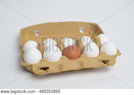 Paper Tray Full Of White Eggs And Only One Different Orange Egg. Discrimination, Xenophobic, Racist 
