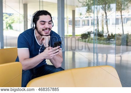 Young Man Using A Smart Phone At Lobby.