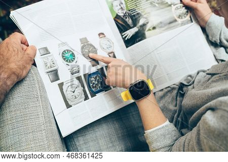 London, United Kingdom - Sept 28, 2022: Woman And Man Reading Large Watch Advertising Inside How To 