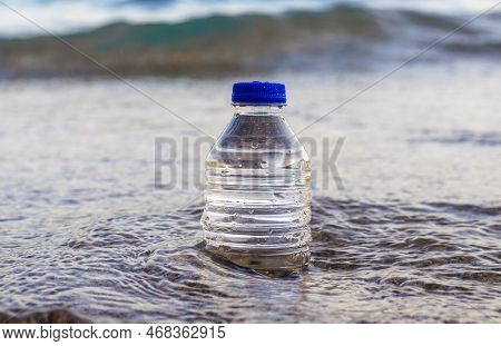 Pebbles In Pyramid One Over Another And Bottle With Drinking Water