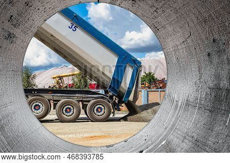A Large Dump Truck Unloads Rubble Or Gravel At A Construction Site. Car Tonar For Transportation Of 
