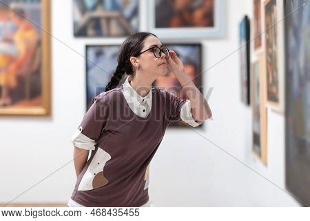 Excursion At Galleryexhibition. Side View Of Caucasian Pretty Young Woman Wearing Glasses Contemplat