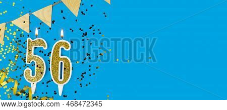 Golden Candle Number Fifty Six. Birthday Or Anniversary Card With The Inscription 56 On Blue Backgro