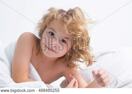 Portrait Of Little Child Lying On Big Bed. Concept Of Happy Children Having Good Time At Home. Child