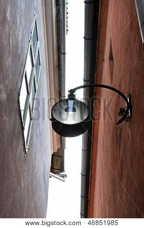 Street lamp hanging in a narrow street in Brasov, Romania