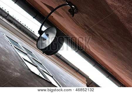 Street lamp hanging in a narrow street in Brasov, Romania