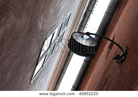 Street lamp hanging in a narrow street in Brasov, Romania