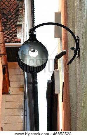 Street lamp hanging in a narrow street in Brasov, Romania