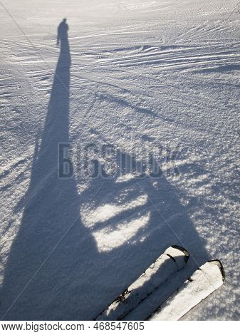 An Elongated Shadow Of A Skier On The Snow Of A Ski Slope, Vertical