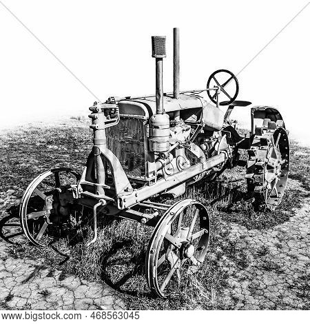 A Black And White Photograph Of A Very Old Tractor Against A White Background.