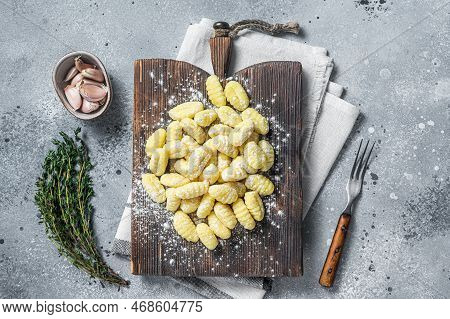 Raw Homemade Potato Gnocchi With Fork On Wooden Cutting Board. Gray Background. Top View.