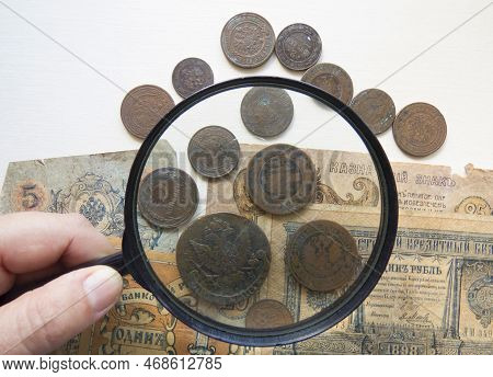 Pile Of Vintage Metall (copper) Coins.  Magnifying Glass And   Coins Of The Russian Empire In The Ba