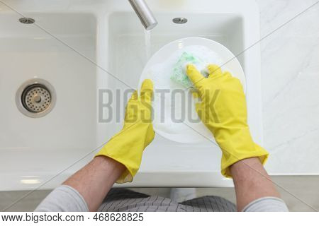 Man Washing Plate In Kitchen Sink, Above View