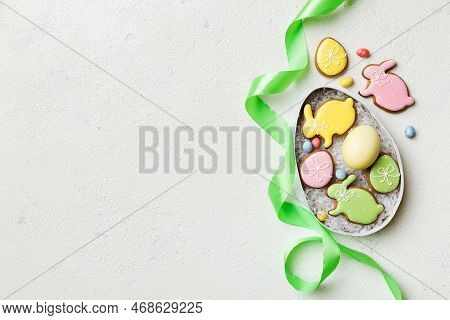 Colorful Easter Cookies In Basket With Multi Colors Easter Eggs On Colored Background . Pastel Color