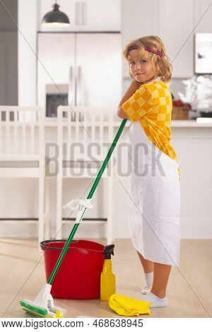 Child Do Chores Cleaning Floor. Child Use Duster And Gloves For Cleaning. Funny Child Mopping House.